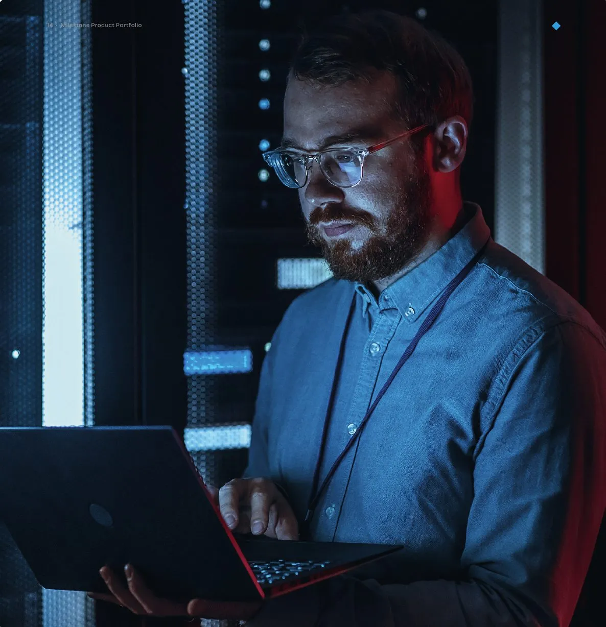 Tekniker med bærbar computer foran et serverrack